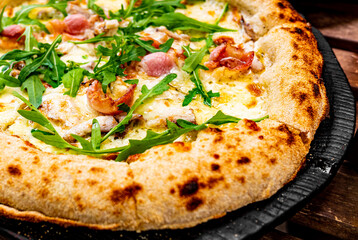 Pizza with Mozzarella cheese, mushrooms, ham, tomato sauce, pepper, Spices and Fresh arugula. Italian pizza on wooden table background