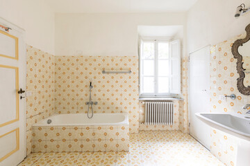 Interior of an old bathroom with window and bathtub. Nobody in this very romantic room.