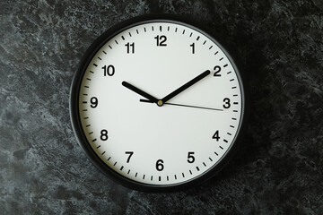 Standard black office clock on black smokey background