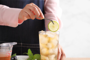 Food stylist use tweezers decorating iced tea with lemon - obrazy, fototapety, plakaty