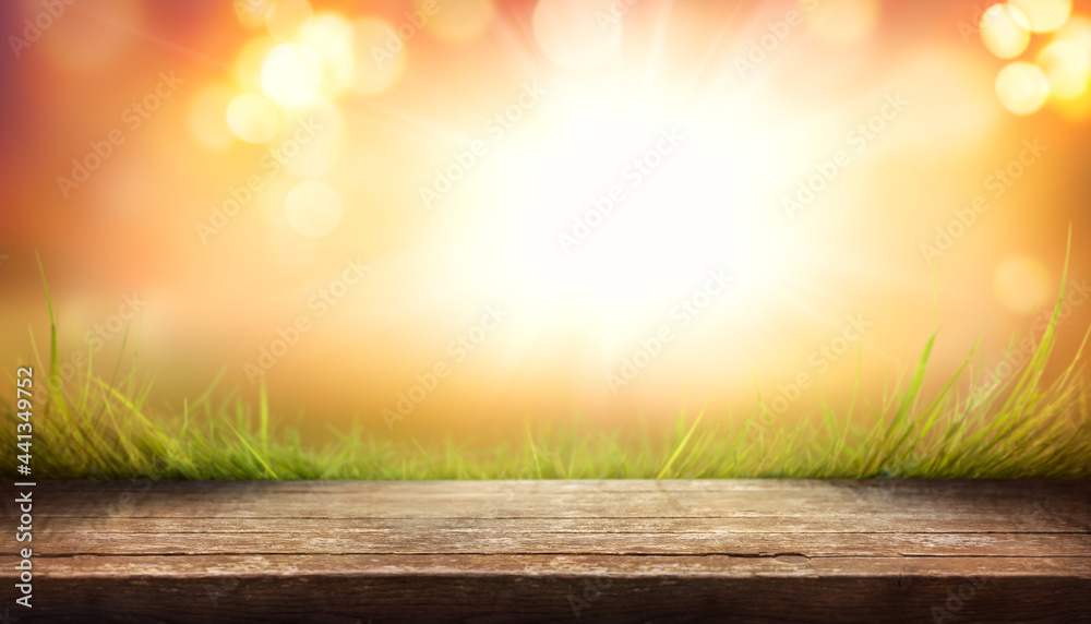 Sticker a wood table product display with copyspace and a golden yellow and orange autumn background for tha