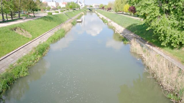A scenic view of water flowing in Bega river by the park at Timisoara, Romania in 4K