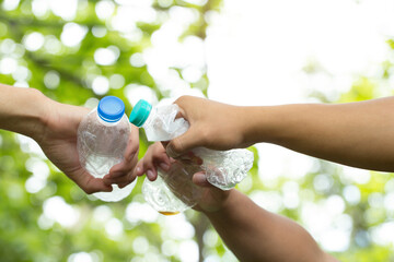 Cooperation Environment Charity Concept.Hands adult Team Work partnership harmony holding plastic bottles together.Environmental and reduce global warming help earth.