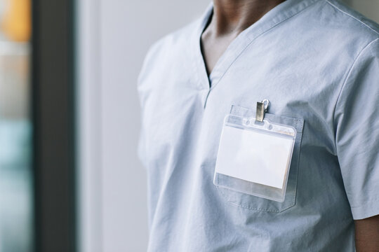 Close up of unrecognizable medical worker wearing blank ID on uniform, copy space