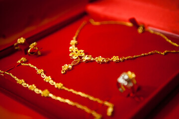 The gold necklace, bracelet and pair of rings for the Chinese wedding are placed in a red flannel...