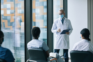 Obraz premium Portrait of medical expert talking to small group of people at medical conference or seminar