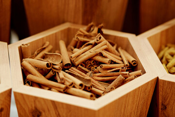 Aromatic dry cinnamon sticks in the wooden box background. Top view