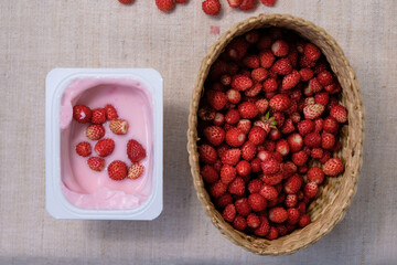 Wild strawberries in yogurt. Berries in a basket. Natural vitamin supplements. Flat lay. 