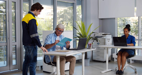 Senior busy man receiving parcel from courier in office