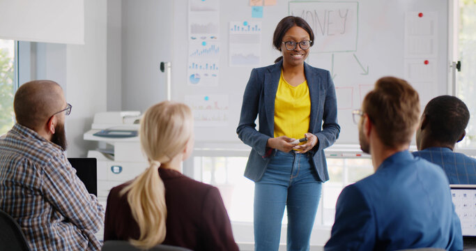 Female african business trainer explaining project data to interns