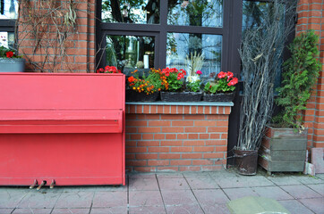 Retro piano painted red on the street, near by the vintage store