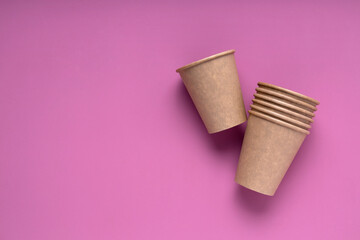 Top view of reusable paper cup on the bright pink surface.Empty space