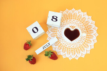 Calendar for July 8 : cubes with the numbers 0 and 8, the name of the month of July in English, a cup of tea in the shape of a heart on a white openwork napkin, strawberries on a yellow background