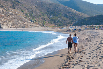 Andros Island, Greece - June 24, 2021: A couple enjoying the sea at a beautiful beach.