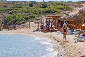 Andros Island, Greece - June 24, 2021: People enjoying the sea at a beautiful beach bar.