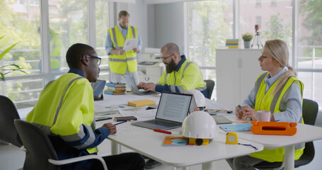 Diverse engineers inspecting in workplace architectural plan