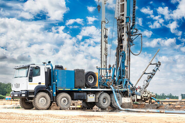 Drilling rig in a field under a blue cloudy sky. Drilling deep wells. Geological exploration....