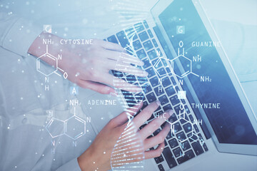 Double exposure of woman hands working on computer and DNA hologram drawing. Top View. Medical education concept.