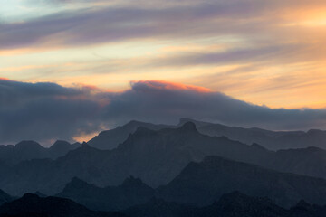 The outline of the mountains is drawn with the sun and clouds in the dawn light in Anaga, Santa Cruz de Tenerife, Canary Islands.