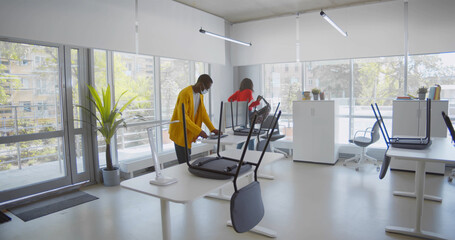 Afro-american workers in safety mask walking in modern empty office