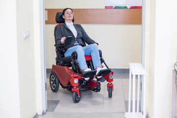 Fototapeta na wymiar Caucasian woman in electric wheelchair in hospital corridor.