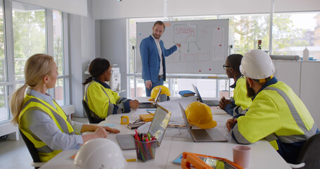 Construction engineers on meeting and presentation in bright modern office