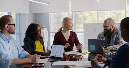 Fototapeta premium Group of young business people working and communicating while sitting at office desk together