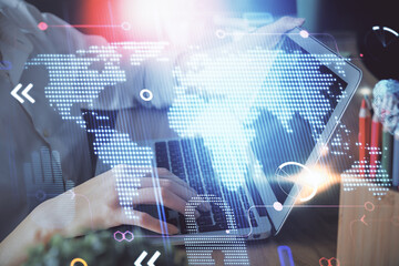 Double exposure of woman hands working on computer and world map hologram drawing. International technology business concept.