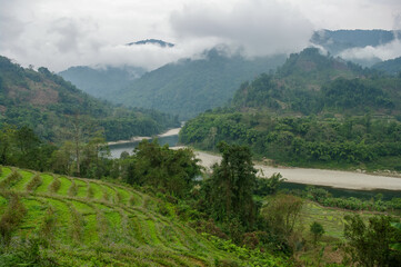 Scenic landscape view of beautiful Siang or Siyom river valley under heavy clouds with terraces in...