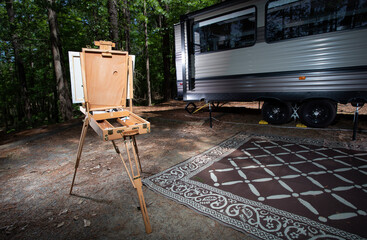 Painting easet set up in front of a travel trailer