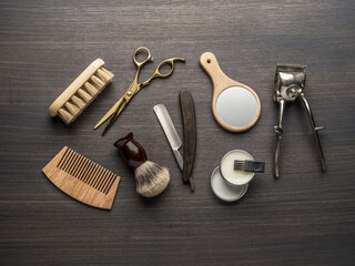 Classic grooming and hairdressing tools on wooden background.
