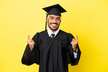 Young university graduate Colombian man isolated on yellow background pointing up a great idea