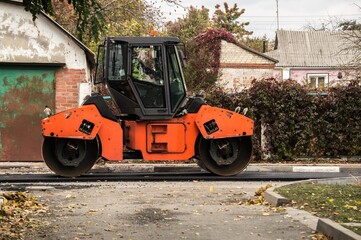 Laying of asphalt. Road roller tamping asphalt