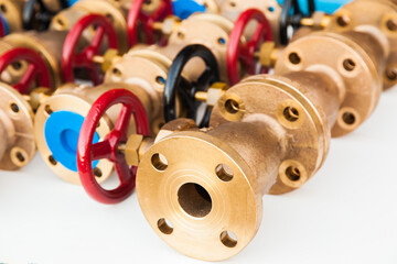 A lot of bronze plumbing valves on a white background.