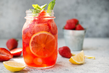 Homemade strawberry lemonade with ice in a jar, summer cold cocktail
