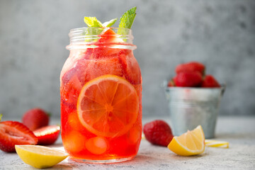Homemade strawberry lemonade with ice in a jar, summer cold cocktail, selective focus