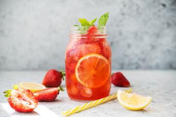 Homemade strawberry lemonade with ice in a jar, summer cold cocktail