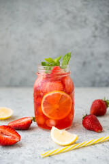 Homemade strawberry lemonade with ice in a jar, summer cold cocktail
