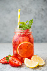 Homemade strawberry lemonade with ice in a jar, summer cold cocktail