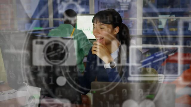 Animation of network of digital icons over smiling businesswoman in office