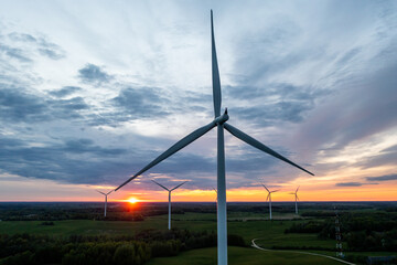 Aerial view of windmill turbines silhouettes in sunset sky in Lithuania.