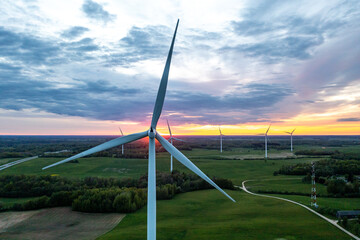 Aerial view of windmill turbines silhouettes in sunset sky in Lithuania.