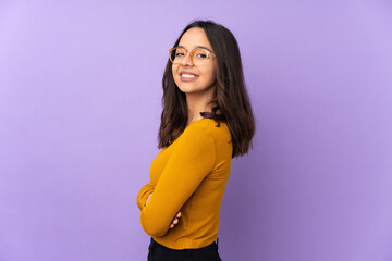 Young mixed race woman isolated on purple background with arms crossed and looking forward