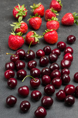 Heap of ripe cherries and strawberry on table
