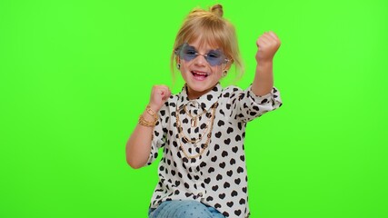 Portrait of funny playful blonde kid child shouting, raising hands in gesture I did it, celebrating success, winning and goal achievemen on chroma key green background. Teenager children girl emotions
