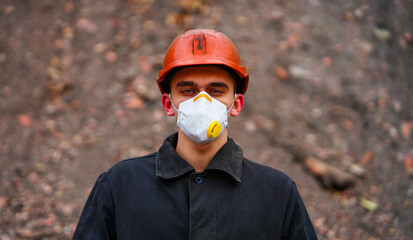 Masked miner miner with scarf on her face and protective helmet with light in a mine tunnel