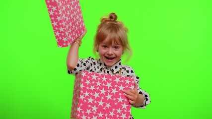 Cheerful stylish little child girl opening gift box, unwrapping birthday surprise and expressing great happiness amazement satisfied with best present bonus. Cute kid on chroma key wall background