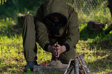 a man tries to make fire in the old way using friction