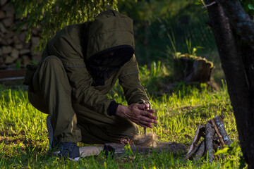 a man tries to make fire in the old way using friction