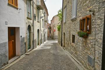 Fototapeta na wymiar A small street between the old houses of Agnone, a medieval village in the mountains of Molise region in Italy.